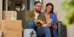 Casal realizando sua mudança para seu primeiro imóvel próprio.