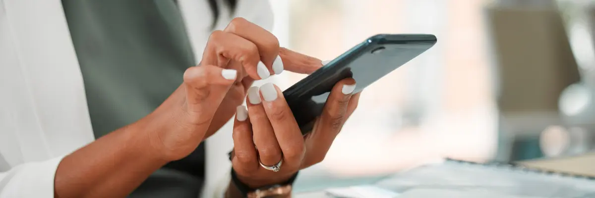 Corretora de imóveis usando seu celular para otimizar suas campanhas de tráfego pago no Facebook.